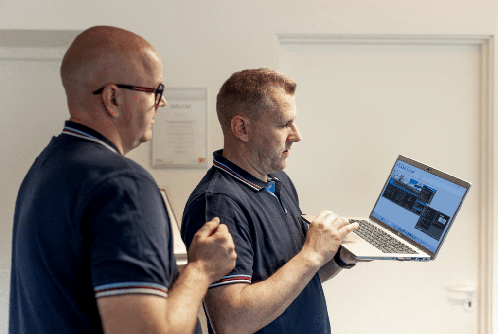 En person viser en kollega et regnskabsprogram på computer.